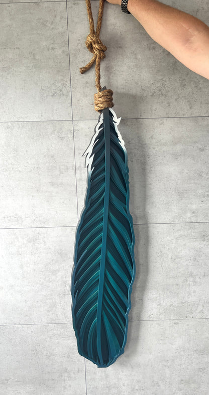 Hanging Tui feather close-up showing hand-painted detail and bamboo texture