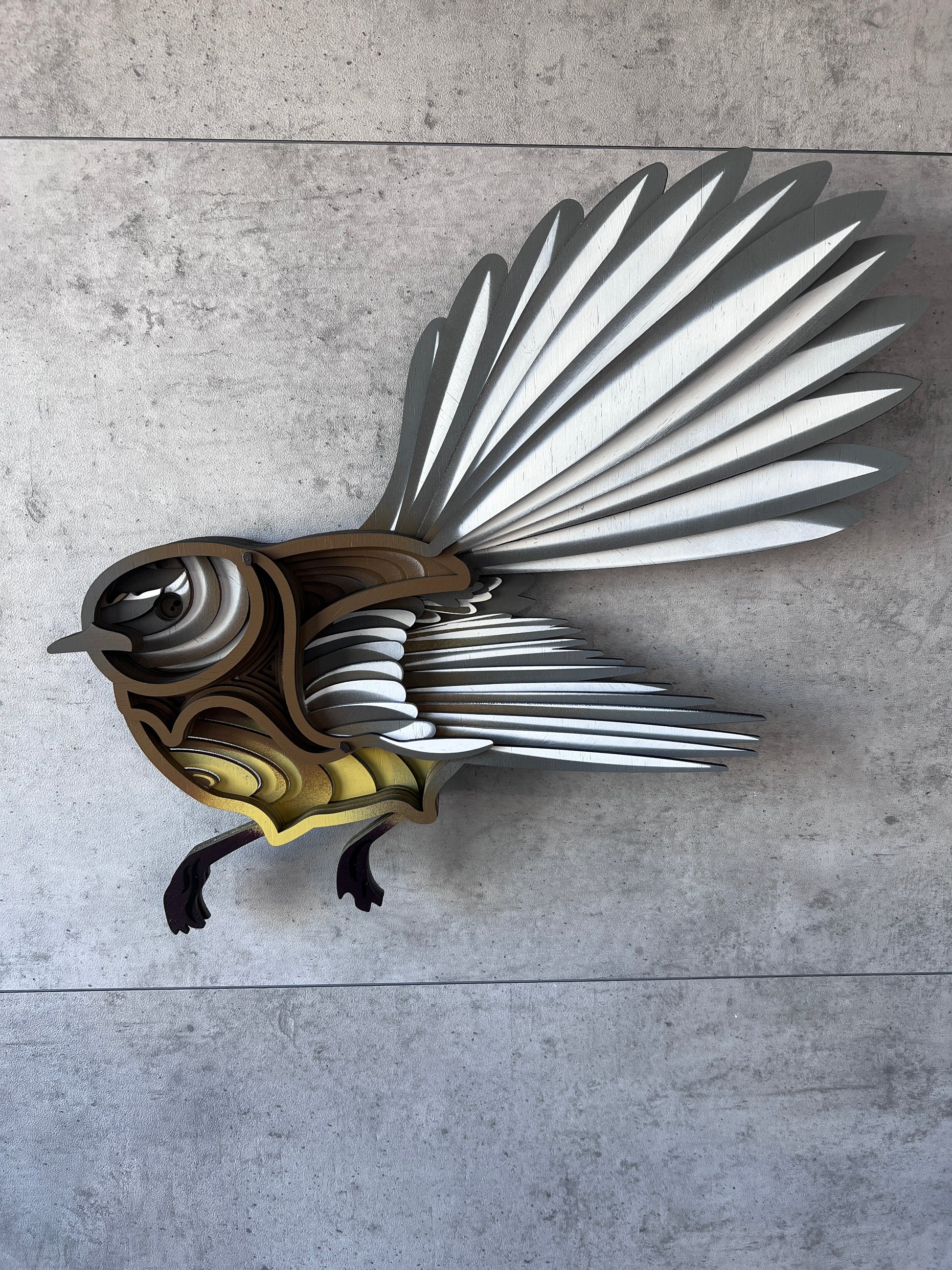 Fantail wall art detail showing hand-painted feathers and bamboo texture